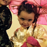 Fillette en kimono avec ombrelle rose