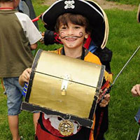 enfant déguisé en pirate tenant un coffre au trésor
